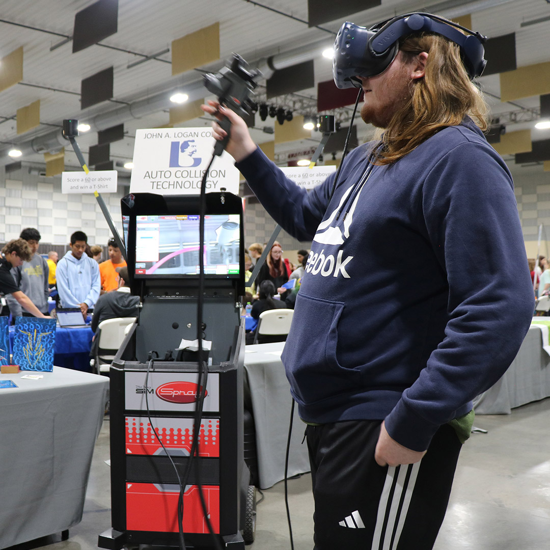 Student explores painting a car using virtual reality technology at the John A. Logan College Automotive display.