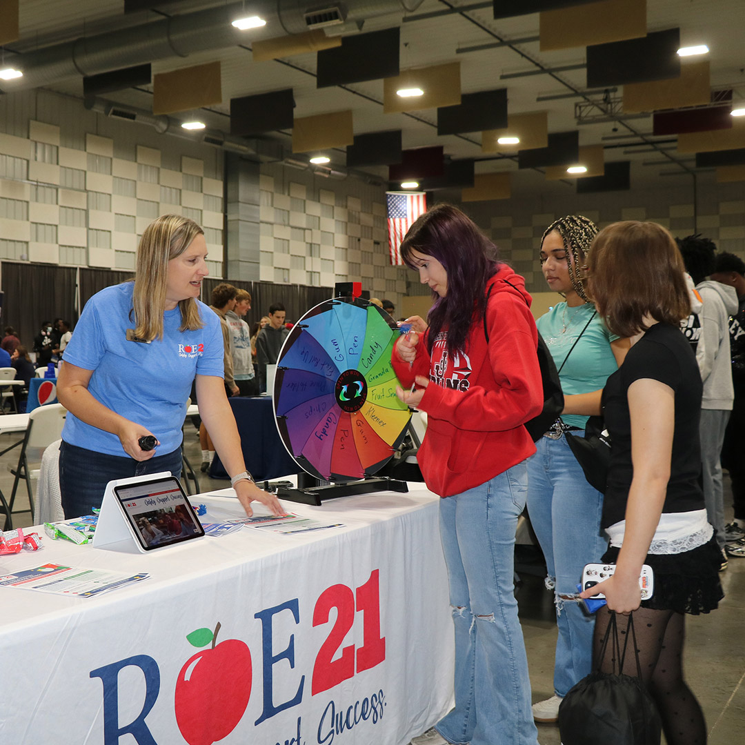 Students line up at the Regional Office of Education #21 table to spin the wheel for prizes.