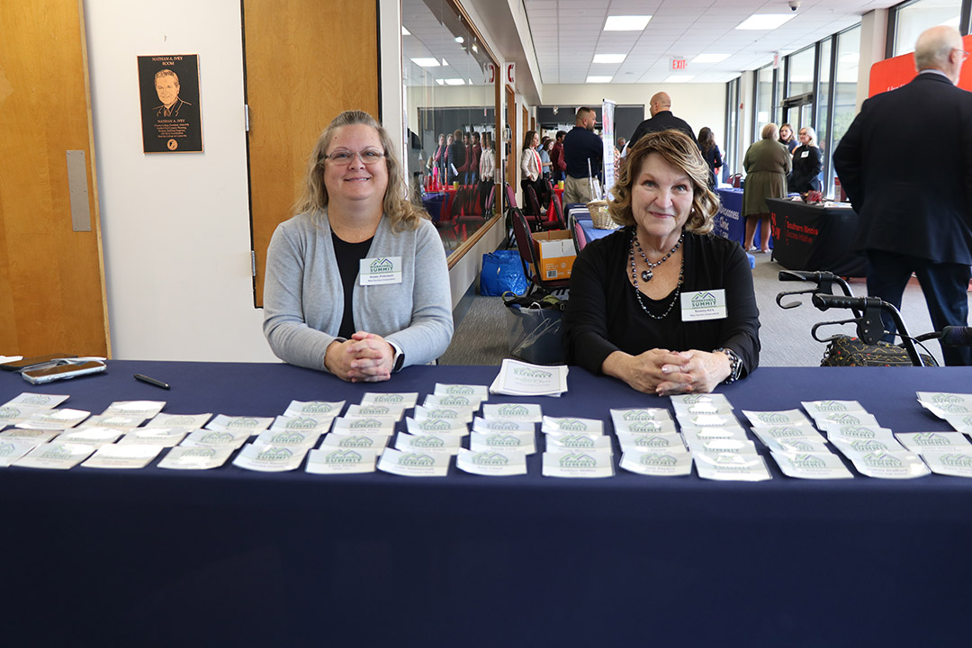 HR & Office Coordinator Robyn Pritchett (left) and Administrative Coordinator/EO Officer Tammy Kirk welcome attendees to the workforce summit.