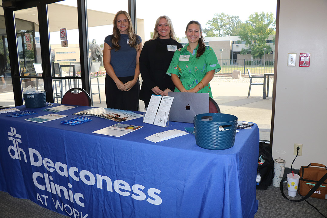 Staff from Deaconess Clinic welcome attendees to their table.