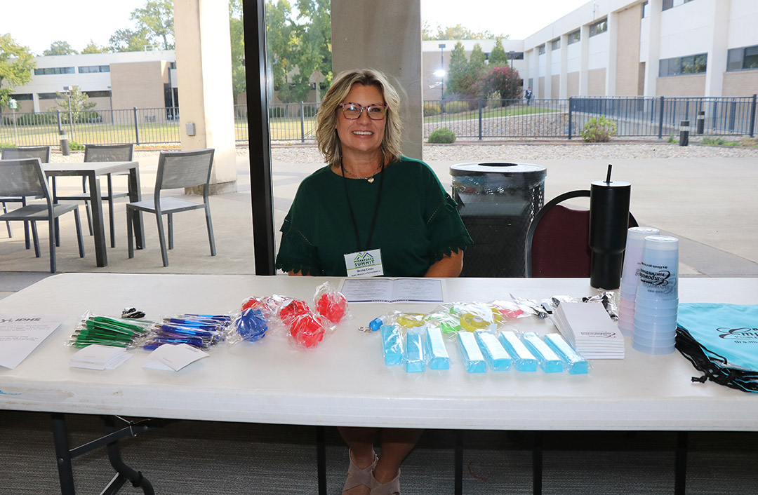 Becky Cross greets attendees at the Illinois Department of Human Services: Division of Rehabilitation Services table.