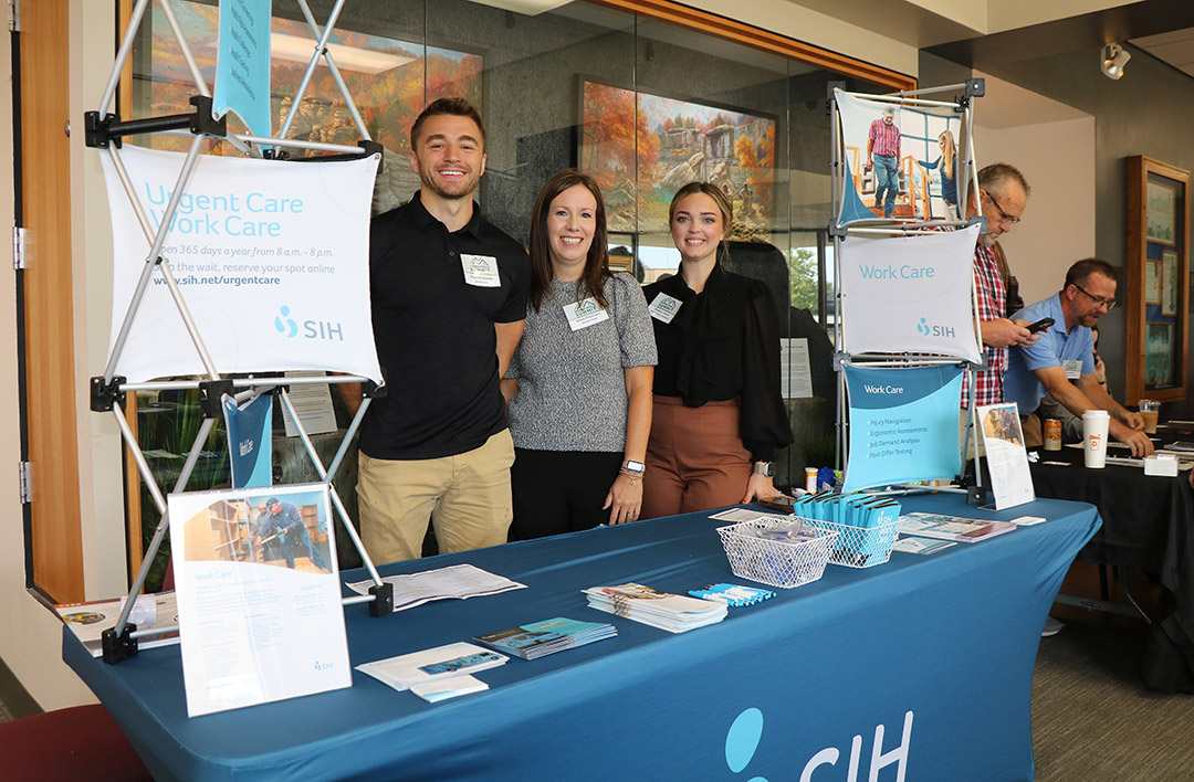 Left to right: Dylan Chrostoski, Kacey Chamness, and Chelsea Lukens greet attendees at the Southern Illinois Healthcare table.